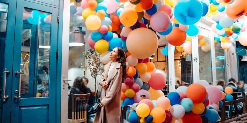 Beautiful woman on the background of wooden door with balloons